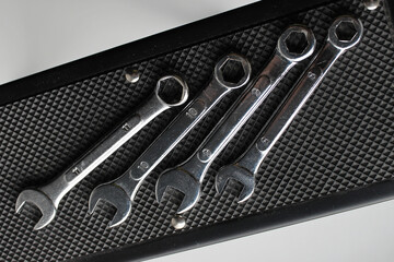 Steel spanners are laid out in ascending order of diameter on a rubber napkin. Hand tools arrangement in order stock photo
