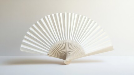 A minimalistic white folding hand fan, elegantly opened and set apart against a clean white background, showcasing its delicate pleats and structure with soft shadows.