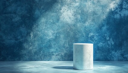Empty marble cylinder display podium on textured blue backdrop