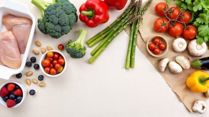 Healthy food ingredients: broccoli, pepper, tomatoes, mushrooms and chicken fillet arranged on a clean surface. Image suitable for nutrition, meal planning, or cooking concept.