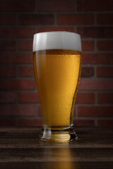 A glass of beer is sitting on a wooden table