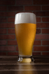 A glass of beer is sitting on a wooden table