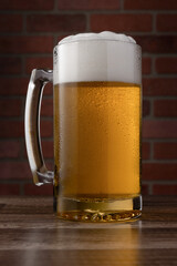A glass of beer is sitting on a wooden table