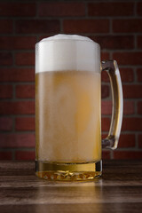 A glass of beer is sitting on a wooden table