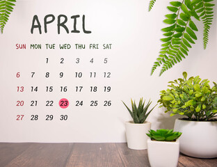 23 April calendar on wooden table with customizable space for text