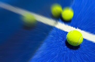 balls near the net of a blue paddle tennis court, sports courts