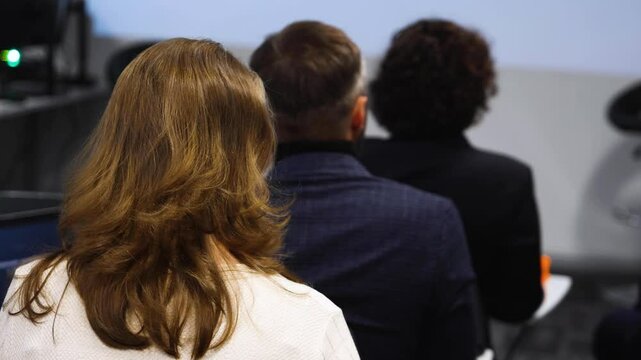 Audience at the modern conference hall listens to panel discussion, people on a congress together listen to speaker on stage at convention, plenary session at business seminar, venue for presentation