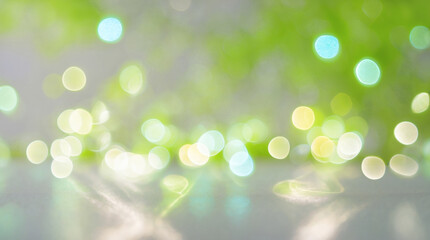Obraz premium Blurred image with soft green, yellow, and white light circles, creating a dreamy, abstract bokeh effect on a light surface.