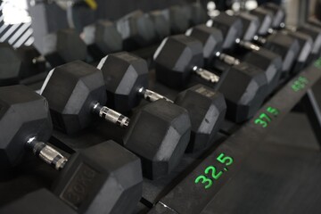 Different many dumbbells in gym. Sport equipment