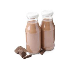 Tasty chocolate milk in glass bottles and pieces of chocolate isolated on white