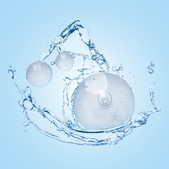 Drops of cosmetic serum and splashing water on light blue background