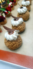 Freshly baked pastry treats with creamy toppings and chocolate accents are displayed enticingly in...