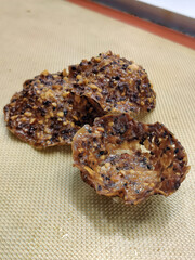 Freshly baked treats featuring a crunchy texture sit on a baking mat, showcasing their rich color and unique shape