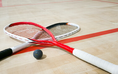 Squash rackets and ball on court floor, top view