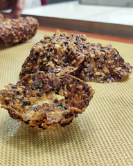 Crispy, textured bakery products are arranged on a wooden board, showcasing their unique shapes and golden color