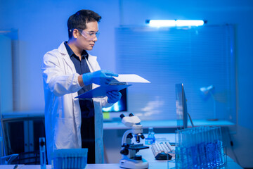 A man in a white lab coat is holding a clipboard