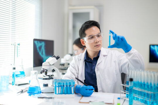 A man in a lab coat holding a test tube