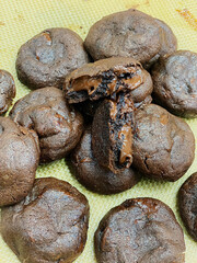 Rows of chocolate chip cookies cool on a baking sheet, ready for customers at a local bakery during busy morning hours