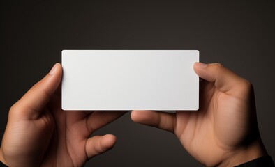 Obraz premium person holding blank white rectangular card mockup against dark background, Mockup Isolated. showcasing minimalist design and providing space for text or branding