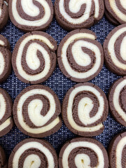 Fototapeta premium Circular cookies are perfectly arranged in rows displaying a delightful combination of chocolate and vanilla flavors