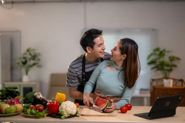 A man and a woman are standing in a kitchen