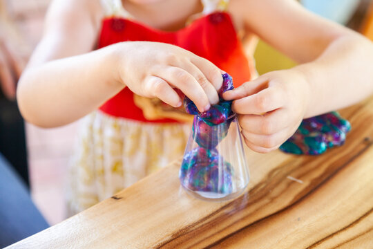 Little girl playing with Christmas gift of slime and goo