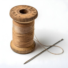 Needle and wooden spool of thread  on white background