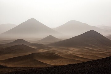 Misty desert landscape of pyramidal mountains