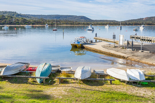 A line of upturned rowboats on the shores of a sheltered bay