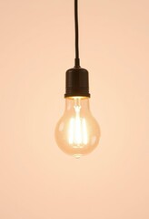 A single, turned-on lightbulb illuminates against a pure white backdrop, product photography, idea, on