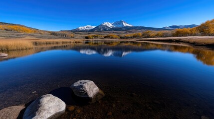 Fototapeta premium Serene mountain lake reflecting peaks in autumn. \