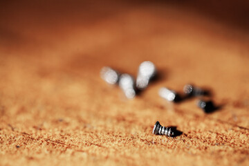 Focus on tiny screw on wooden tabletop