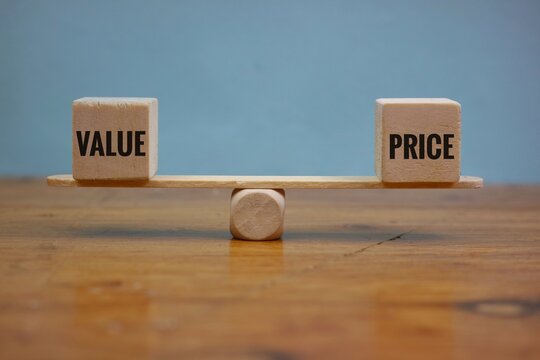 Wooden Blocks Showing Price and Value on a Balanced Scale