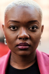 Obraz premium Confident businesswoman with short blonde hair and nose piercing posing for portrait