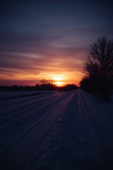 Obraz premium Sunset over snowy railroad tracks.