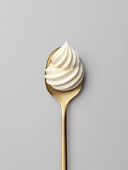 Elegant golden spoon holding a swirl of creamy dessert, perfect for culinary delights.