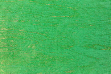 shabby painted green plywood texture with cracks and peeling of paint. closeup view.