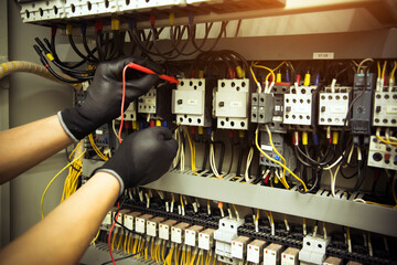 Electrical technician hand is checking circuit breaker power electricity on switchboard cabinet for...