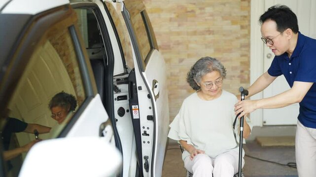 Asian man caregiver or taxi driver helping senior woman patient get in car to get to medical appointments or healthcare therapy sessions at hospital. Assisted elderly patient transportation services.