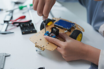 Student building robot car in science class