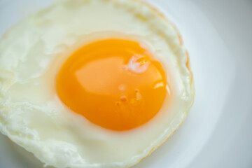 Fried egg on white dish close up