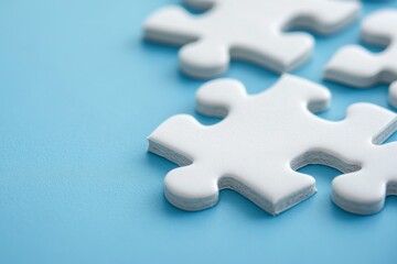 Obraz premium White jigsaw puzzle pieces on a blue background.