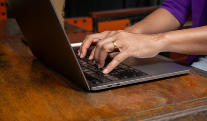 Businesswoman sitting outside at cafe hand typing on laptop on table, online working searching, freelancer work concepts
