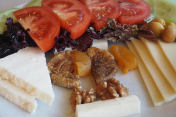 Fresh fruits and cheeses arranged on a plate for a summer snack