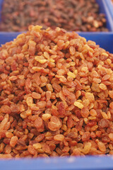 Dried golden raisins displayed at a market stall in the afternoon