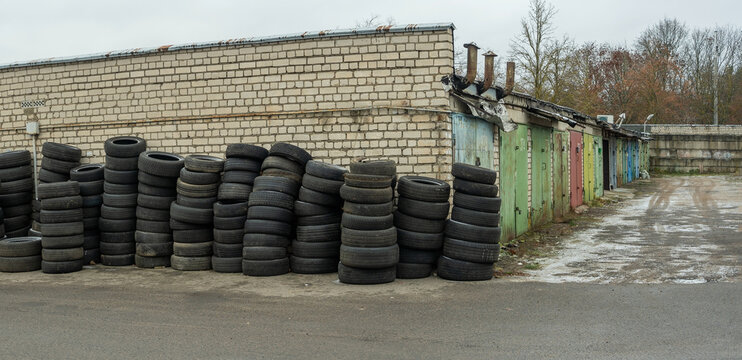 Panoramic view of storage of discarded old car tires outdoors, showcasing a pile of used tires ready for recycling. Highlighting environmental concerns and rubber waste management