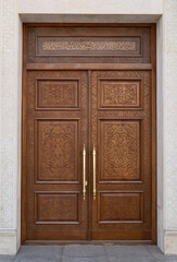 Ornate Wooden Carved Doorway with Gold Handles
