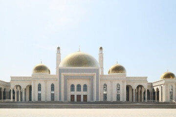 Fototapeta premium A beautiful central city mosque in Almaty, Kazakhstan, with a golden dome and tall minarets under a clear sky
