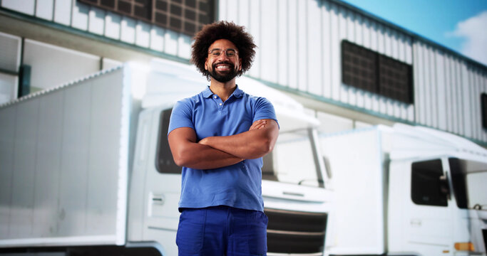 Happy technician in overall near van, service truck for maintenance