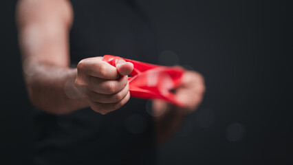 Intense Close Up Red Resistance Band Warm Up Exercise Dark Background Workout Activity, Shallow Depth Of Field Focus On Hands And Band